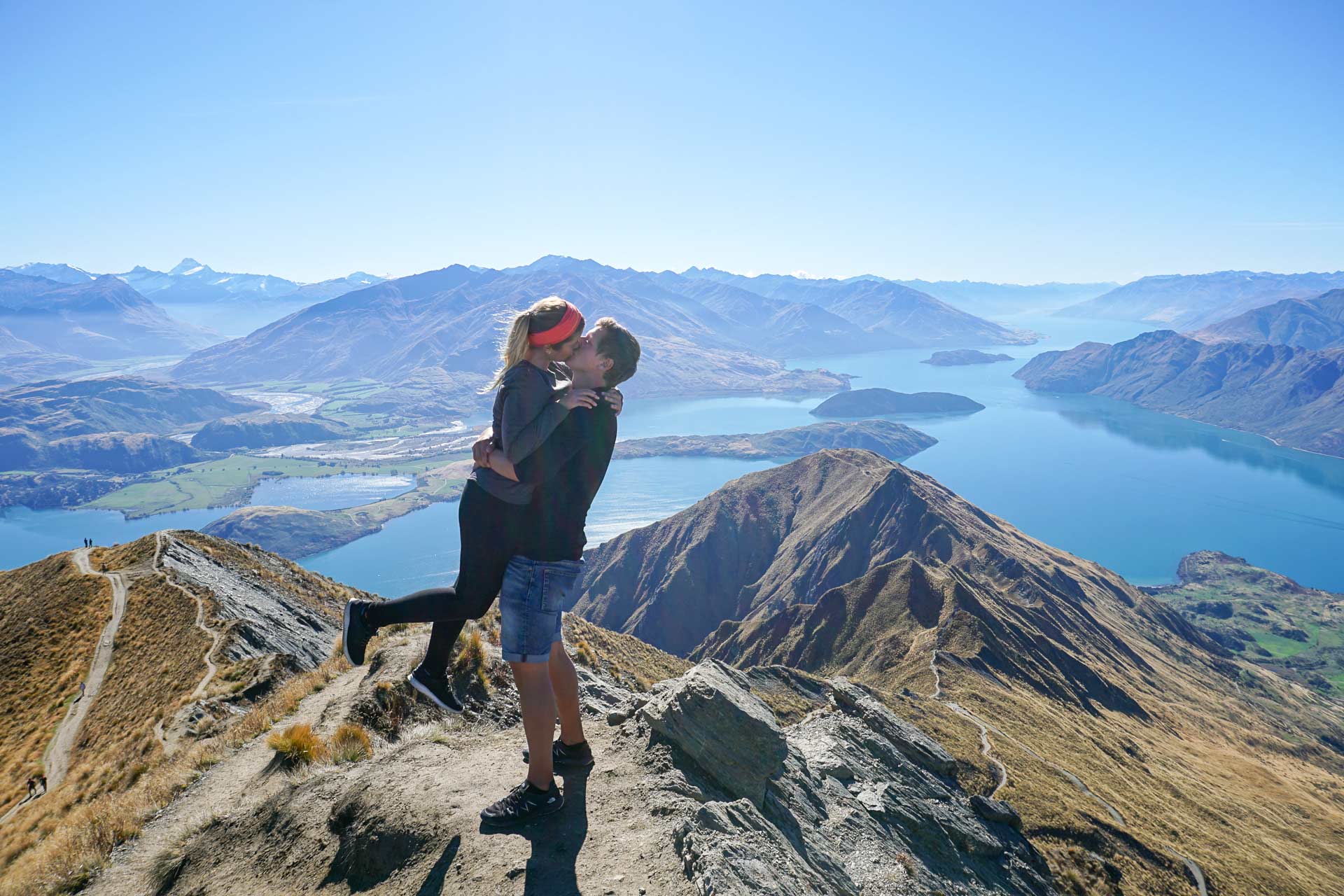 Edgar und Katy gemeinsam auf dem Gipfel des Roys Peak in Neuseeland und küssen sich