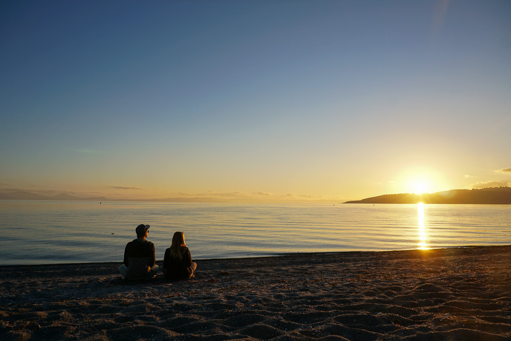 Katy und Edgar sitzen zum Sonnenuntergang am Lake Taupo